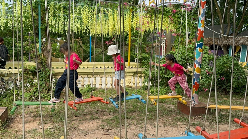 A group of children playing on swings

Description automatically generated