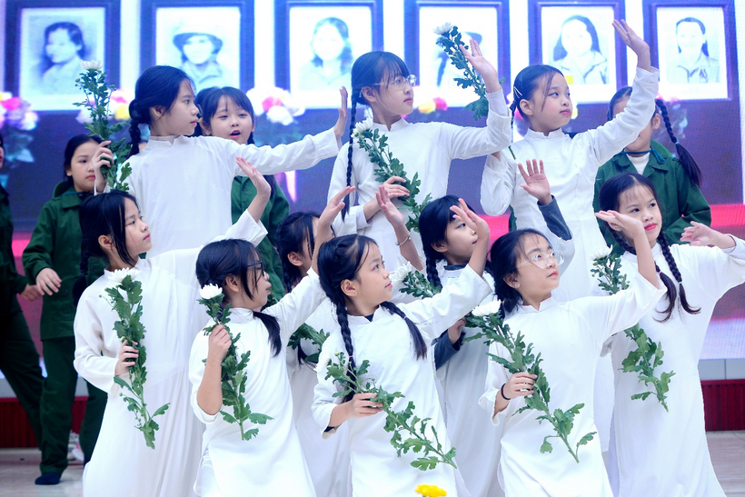 A group of children in white dresses holding flowers

Description automatically generated