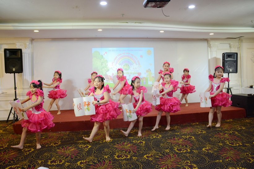 A group of young girls in pink dresses dancing on a stage

Description automatically generated with low confidence