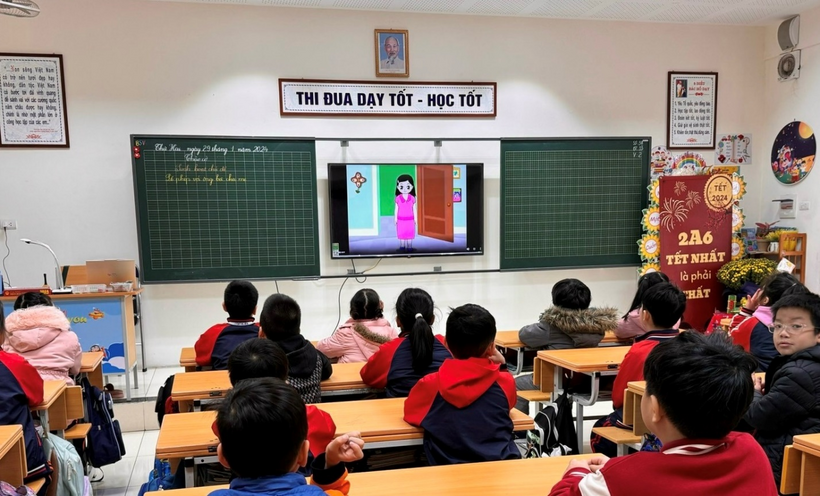 A group of children in a classroom watching a cartoonDescription automatically generated