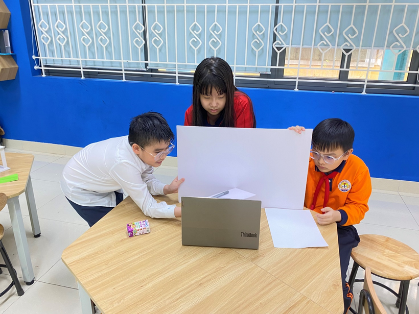 A group of kids looking at a paperDescription automatically generated