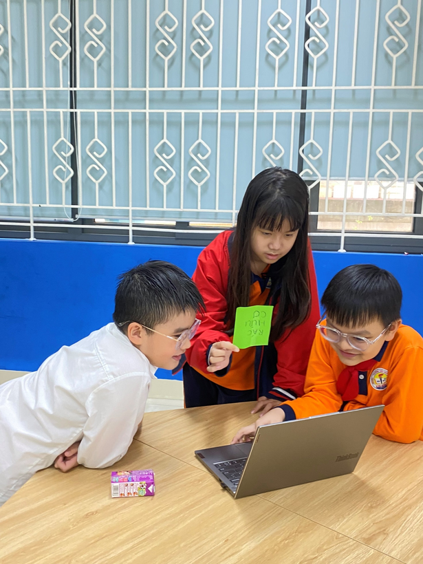 A group of kids looking at a computerDescription automatically generated