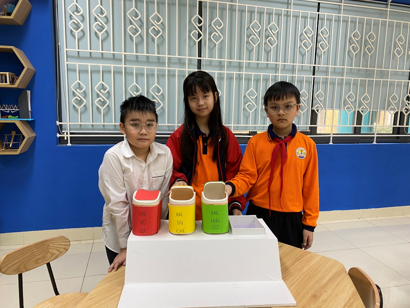 A group of kids standing next to a table with colorful containersDescription automatically generated