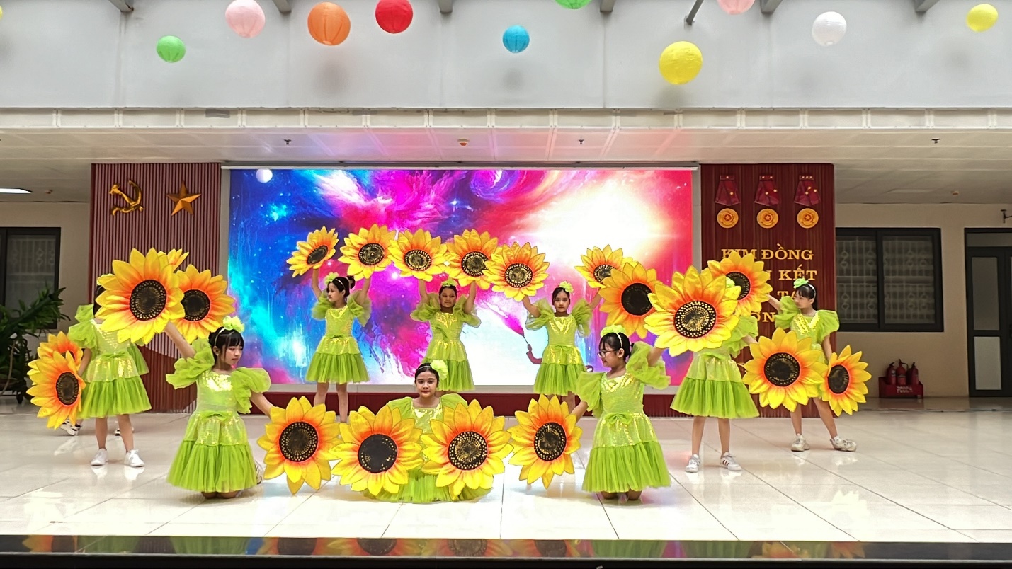 A group of girls in green dresses dancing with sunflowers

Description automatically generated