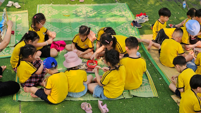 A group of kids sitting on a blanket on grass

Description automatically generated
